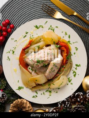 Gebackene Makrele mit Esccalivada-Gemüse, Paprika, Zwiebeln und Auberginen. Tisch mit Panoramablick und Weihnachtsdekoration. Stockfoto