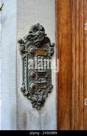 Alte Vintage, geschnitzte und dekorierte Buzzer oder Sprechanlage an einer Außenwand neben der Eingangstür. Nahaufnahme, keine Leute. Stockfoto