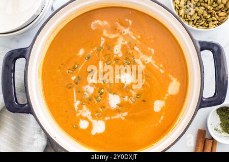 Butternusskürbis-Suppe in einem Topf mit Sahne und Samen Stockfoto