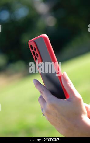 Person, die ein Smartphone verwendet, das Mobiltelefon hält, ein Foto aufnimmt, unscharfen Hintergrund Stockfoto