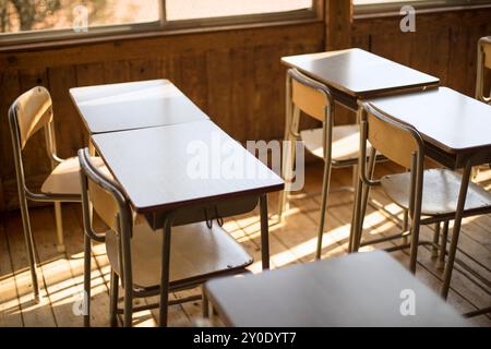 Schreibtische und Stühle in einem hölzernen Schulgebäude Stockfoto