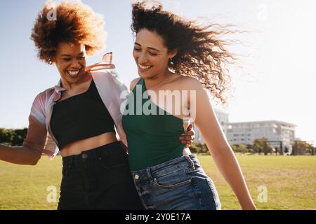 Zwei sorglose Freunde genießen einen sonnigen Tag im Freien mit Lächeln und Lachen, um das Wesen von Glück und Freundschaft festzuhalten. Stockfoto
