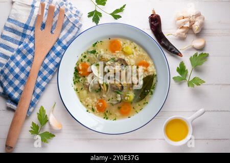 Reis-, Gemüse- und Muschelsuppe, traditionelle spanische Tapa. Tisch mit Blick von oben mit Weihnachtsdekoration. Stockfoto