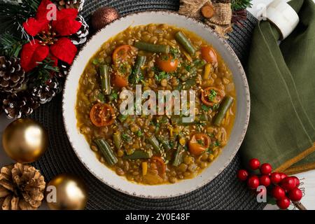 Linsensuppe mit grünen Bohnen und Kirschtomaten. Tisch mit Panoramablick und Weihnachtsdekoration. Stockfoto