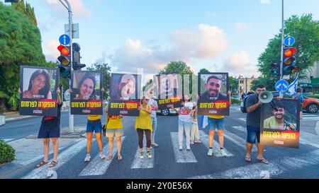 Haifa, Israel - 01. September 2024: Menschen marschieren auf der Straße mit Plakaten der sechs Geiseln, die in Gaza getötet wurden, Teil eines Abends der Empörung r Stockfoto