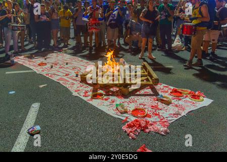 Haifa, Israel - 01. September 2024: Symbolische Darstellung blutiger Hände und Feuer aus Protest, Teil einer abendlichen Kundgebung, in der ein Gastgeber aufgerufen wurde Stockfoto