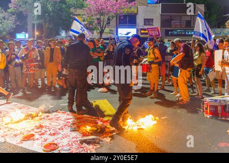 Haifa, Israel - 01. September 2024: Symbolische Darstellung blutiger Hände und Polizei löscht Feuer, Teil einer abendlichen Kundgebung, die zu einem h aufruft Stockfoto