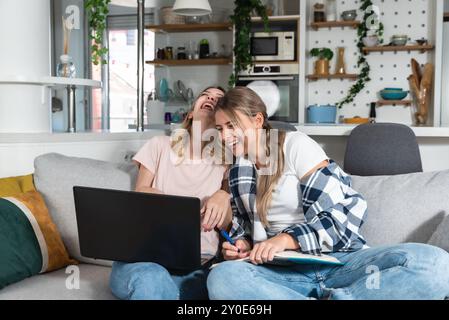 Zwei weibliche Mitbewohner, kleine Firmenbesitzer, die zu Hause auf einem Laptop arbeiten. Zusammenarbeit im Internet, Entwickler von Startup-Unternehmen, Designer und Onlin Stockfoto