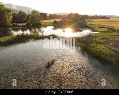 Glückliches Paar, das im Sommer eine Kanufahrt auf dem See genießt und sich inmitten der wunderschönen grünen Natur entspannt. Konzepte für Kanufahrten. Stockfoto