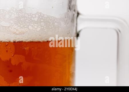 Eine Aufnahme, die die komplizierten Details eines getoasteten Bierglaskörpers zeigt. Das Glas ist im Bild zentriert, vor einem sauberen weißen Hintergrund, wodurch i hervorgehoben wird Stockfoto