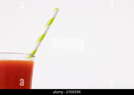 Eine Nahansicht eines Bloody Mary Cocktails mit einem Strohhalm auf der linken Seite eines horizontalen Bildes. Der Hintergrund ist schlicht weiß und betont Stockfoto