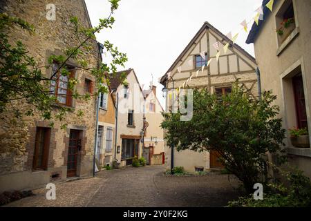 Kopfsteinpflasterstraße und Fachwerkhäuser im mittelalterlichen Dorf Mennetou-sur-Cher, Frankreich. Vertikale Aufnahme. Stockfoto