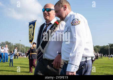 Mitglied von Crumlin RBP 379 mit Mitglied von Lambeg Orange und Blue Flöte Band auf dem Assembly Field. Ballymena, Großbritannien - 31. August 2024. Stockfoto