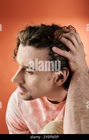 Ein beeindruckendes Porträt eines Mannes, der in Gedanken verloren ist, mit einem lebendigen Hintergrund. Stockfoto