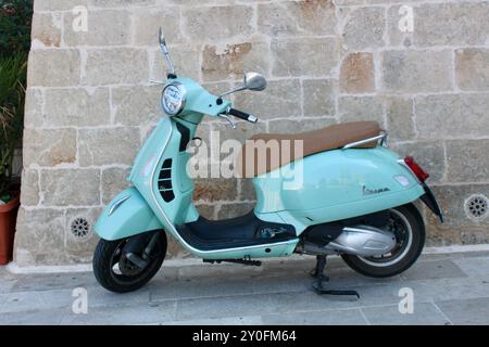 Türkisfarbenes, blassblaues Aqua vespa GT300, geparkt an einer Steinmauer; verschiedene vespa-Motorroller parken auf den Straßen von Monopoli apulien an der adriaküste Stockfoto