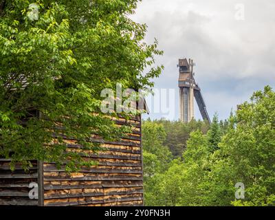 Erkunden Sie den rustikalen Charme der John Brown Farm, wo eine zeitlose Holzscheune stolz mit dem majestätischen olympischen Skisprungturm steht Stockfoto