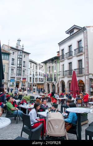 Leute, die auf Terrassen sitzen, am Hauptplatz. Llanes, Asturien, Spanien. Stockfoto