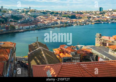 Blick von Porto, Portugal von der Altstadt mit orangefarbenen Dächern und einer kleinen Kirche am Fluss Douro an sonnigen Tagen. Beliebtes Touristenziel in Europa Stockfoto