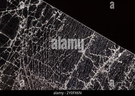 Verschmutztes Glas, das in eine große Anzahl von Teilen zerbrochen ist, ein Stück Glas mit vielen Rissen und gebrochenen Teilen Stockfoto