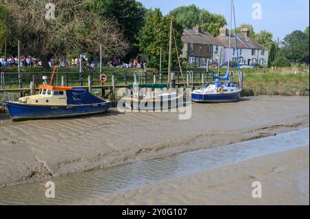 Faversham, Kent, Großbritannien. Menschen, die während des Hop Festivals vor einem Pub trinken, und Boote, die im Faversham Creek - dem Einlass der Themse - bei Lo vor Anker liegen Stockfoto