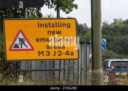 September 2024. Ein Programm zur Schaffung zusätzlicher Notbereiche auf Abschnitten der Autobahn ALR (All Lane Running) im ganzen Land ist im Gange. Diese Autobahnen werden allgemein als intelligente Autobahnen bezeichnet. Abgebildet: Ein Straßenschild mit der Aufschrift Installation neuer Notfallbereiche M3 J2-4a in der Nähe von Farnborough, Hampshire, England, Großbritannien. Stockfoto