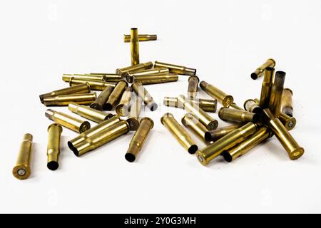 Goldene Gewehrpatronen oder leere Gehäuse, die in einen Stapel auf weißem Hintergrund fallen Stockfoto