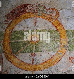 Die Heilige Katharina von Alexandria liegt auf einem brechenden Rad. Detail des mittelalterlichen Freskos, Abbazia di Piona (Abtei Piona), Colico, Lombardei, Italien. Das Fresko ist insofern ungewöhnlich, als die Heilige Katharina häufiger als triumphierend mit dem zerstörten Rad dargestellt wird. Stockfoto