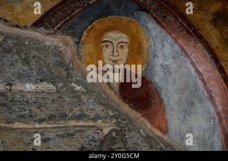 Wachsame Augen eines bärtigen heiligen. Detail aus dem mittelalterlichen Fresko im Kreuzgang der Abbazia di Piona (Abtei Piona) in Colico, Lombardei, Italien. Stockfoto