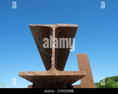 Rostiger Stahlbalken mit Doppel-T-Profil, der von einem alten Pier überliefert ist, symbolisiert industrielle Relikte und die Tragkraft vergangener Bauwerke. Stockfoto