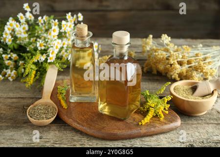 Tinkturen in Flaschen und Heilkräuter auf Holztisch Stockfoto