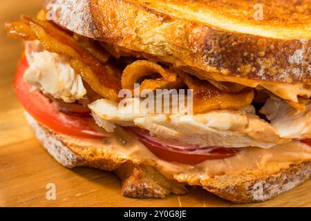 Scharfes hausgemachtes Chipotle Chicken Sandwich Panini mit Speck und Tomaten Stockfoto