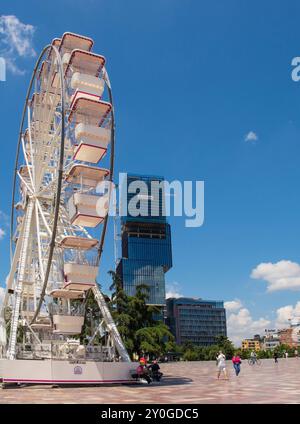 Tirana, Albanien - Mai 30 2024. Das Tirana Eye Ferris Wheel auf dem Skanderbeg Square im Zentrum von Tirana. Die Augen des Wolkenkratzers Tirana sind im Hintergrund Stockfoto