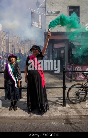 Windsor, Großbritannien, 1. September 2024. Ein Demonstrator hält eine grüne Rauchfackel. Mitglieder der Extinction Rebellion halten eine dreitägige Demonstration vor dem Gelände von Windsor Castle ab. Die Fraktion fordert die neue Labour-Regierung auf, eine Bürgerversammlung zur Bekämpfung des Klimawandels einzurichten. Quelle: James Willoughby/Alamy Live News Stockfoto