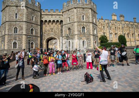 Windsor, Großbritannien, 1. September 2024. Protesttrommler treten vor dem Eingang eines Schlosses auf. Mitglieder der Extinction Rebellion halten eine dreitägige Demonstration vor dem Gelände von Windsor Castle ab. Die Fraktion fordert die neue Labour-Regierung auf, eine Bürgerversammlung zur Bekämpfung des Klimawandels einzurichten. Quelle: James Willoughby/Alamy Live News Stockfoto