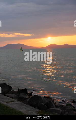 Wunderschöner Sonnenuntergang über dem Balaton mit einer Windsurferin Stockfoto