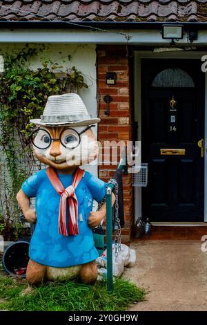 Riesige Plastik-Eichhörnchen-Statue Dekoration im Garten vor einem britischen Haus. Exzentrisch. Seltsam. Ungewöhnlich. Humorvoll. Schrullig. Abstrakt. Konzept. Stockfoto