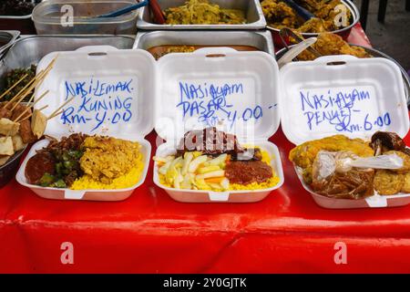 Authentisches malaysisches Streetfood in Take-Out-Behältern, die mit Preisen gekennzeichnet sind Stockfoto