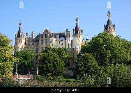 Malerischer Blick auf das historische deutsche Schloss Schweriner mit grünem Garten vor hellblauem Himmel. Berühmtes Reiseziel in Europa. Stockfoto