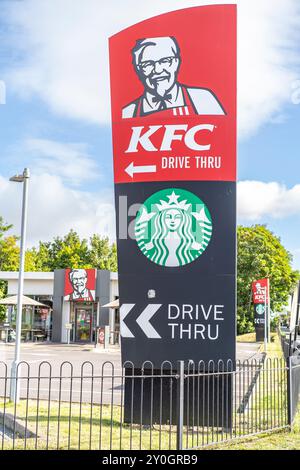 Beschilderung für ein KFC und Starbucks Drive-Thru Restaurant an einem hellen sonnigen Tag. Stockfoto