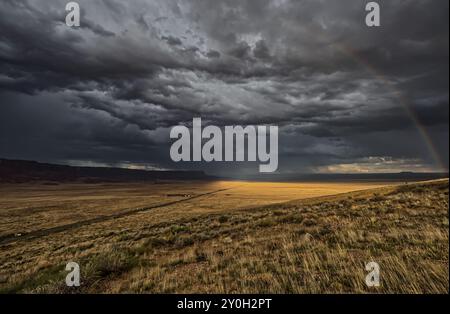 Dunkle Sturmwolken mit einem schwachen Regenbogen über dem Vermilion Cliffs National Monument Arizona. Stockfoto