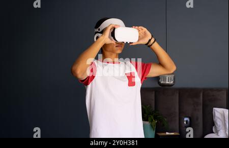 Mit dem VR-Headset erkundet ein junger asiatischer Mann die virtuelle Realität in Innenräumen Stockfoto