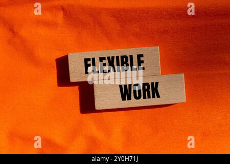 Flexible Arbeitsbotschaft auf Holzblöcken mit orangefarbenem Hintergrund. Konzeptionelles flexibles Arbeitssymbol. Kopierbereich. Stockfoto