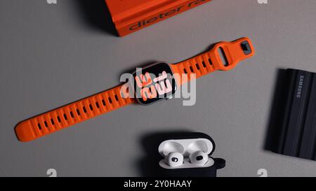 LONDON - 26. AUGUST 2024: Apple Watch mit leuchtend orangefarbenem Bandarmband und Uhrenblatt Stockfoto