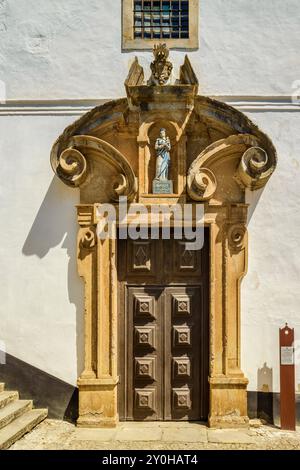 Tür an der Fassade der Kirche des Heiligen Hauses der Barmherzigkeit in Óbidos, einer antiken mittelalterlichen ummauerten portugiesischen Stadt, charmant und attraktiv in Portugal Stockfoto