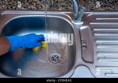 Reinigen Sie das schmutzige Waschbecken in der Küche mit Wasser in Nahaufnahme Stockfoto