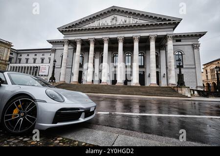 München – 17. April 2024: Münchner Nationaltheater oder Nationaltheater auf dem Max-Joseph-Platz. Heimat der Bayerischen Staatsoper mit einem porsche 911 Stockfoto