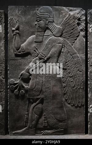 München, Deutschland - 17. April 2024: Geflügelte und bärtige Dschinken mit verschiedenen Attributen, Assyrisches Flachrelief im Ägyptischen Staatsmuseum Stockfoto