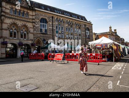 Straßenmarkt mit Zelten und Ständen vor einem historischen Gebäude, wo Menschen an einem sonnigen Tag in Winchester UK spazieren gehen und einkaufen können Stockfoto