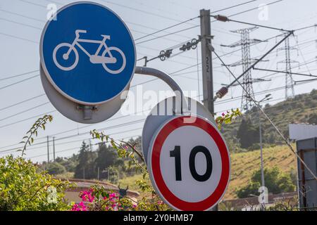 Fahrradschild und Geschwindigkeitsbegrenzungsschild stehen in einer städtischen Umgebung, was darauf hindeutet, dass der Schwerpunkt auf nachhaltigem Transport und umweltfreundlichem Pendeln liegt Stockfoto