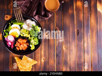 Reis mit rotem Fisch, grünen Bohnen und Brokkoli auf einer schwarzen Platte. Diät. Draufsicht. Freier Platz für Text. Stockfoto